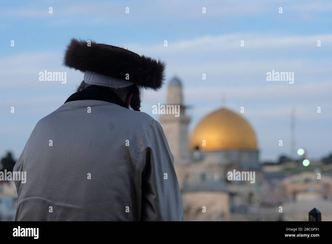 Un juif hassidique portant un shtreimel un chapeau de fourrure porté par de nombreux hommes juifs haredi mariés regarde le Dôme du Rocher un sanctuaire islamique situé sur le Mont du Temple connu des musulmans comme le Haram esh-Sharif dans la vieille ville de Jérusalem-est Israël Banque D'Images