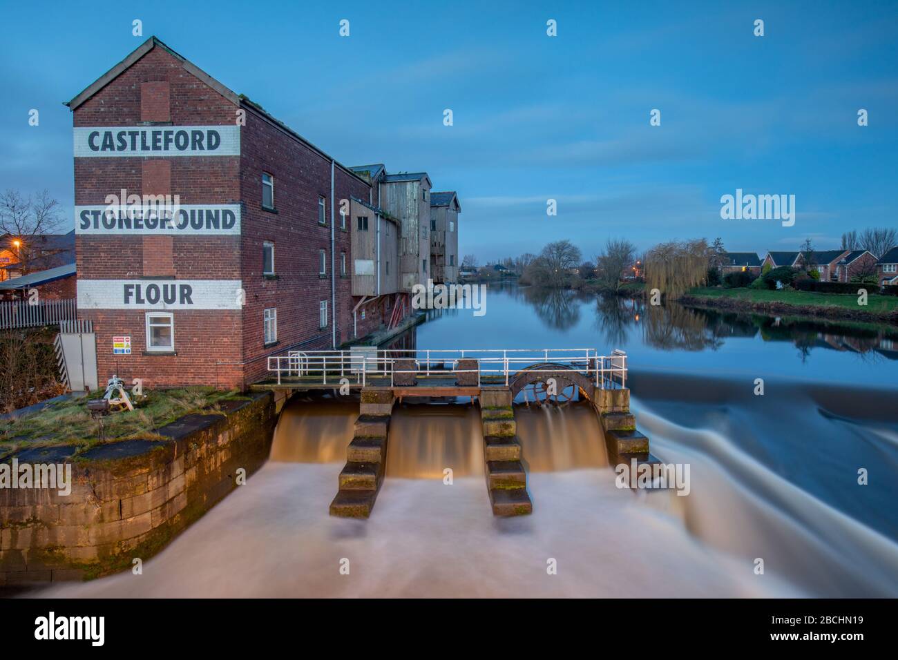 Castleford West Yorkshire, Angleterre. Matin à la rivière aire, stoneground Allinsons minal moulin et Weir près du pont du Millénaire et du centre-ville Banque D'Images