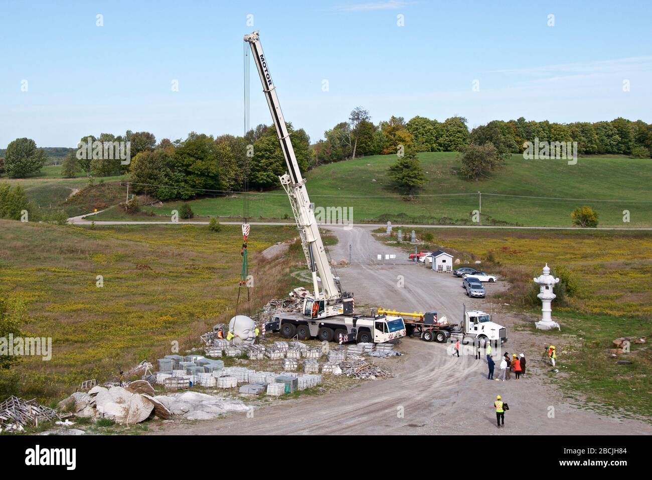 Vue aérienne de la transpiration de la statue de pierre par camion de grue dans le bâtiment du Bouddha Maitreya. Banque D'Images