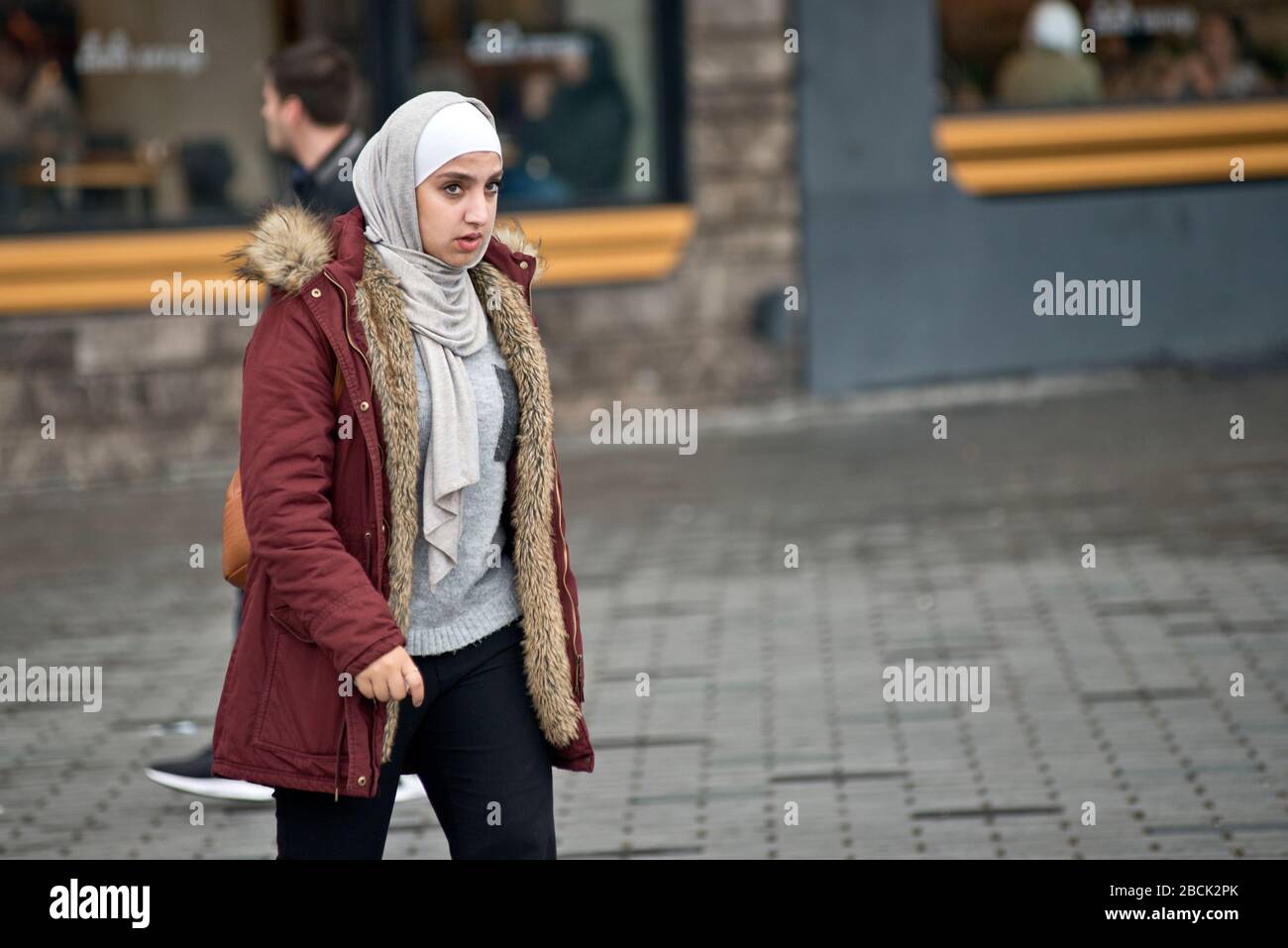Une fille musulmane portant un pashmina et un manteau d'hiver. Place Taksim, Istanbul. Turquie Banque D'Images