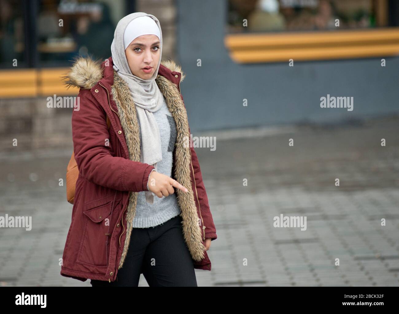 Une fille musulmane portant un pashmina et un manteau d'hiver. Place Taksim, Istanbul. Turquie Banque D'Images