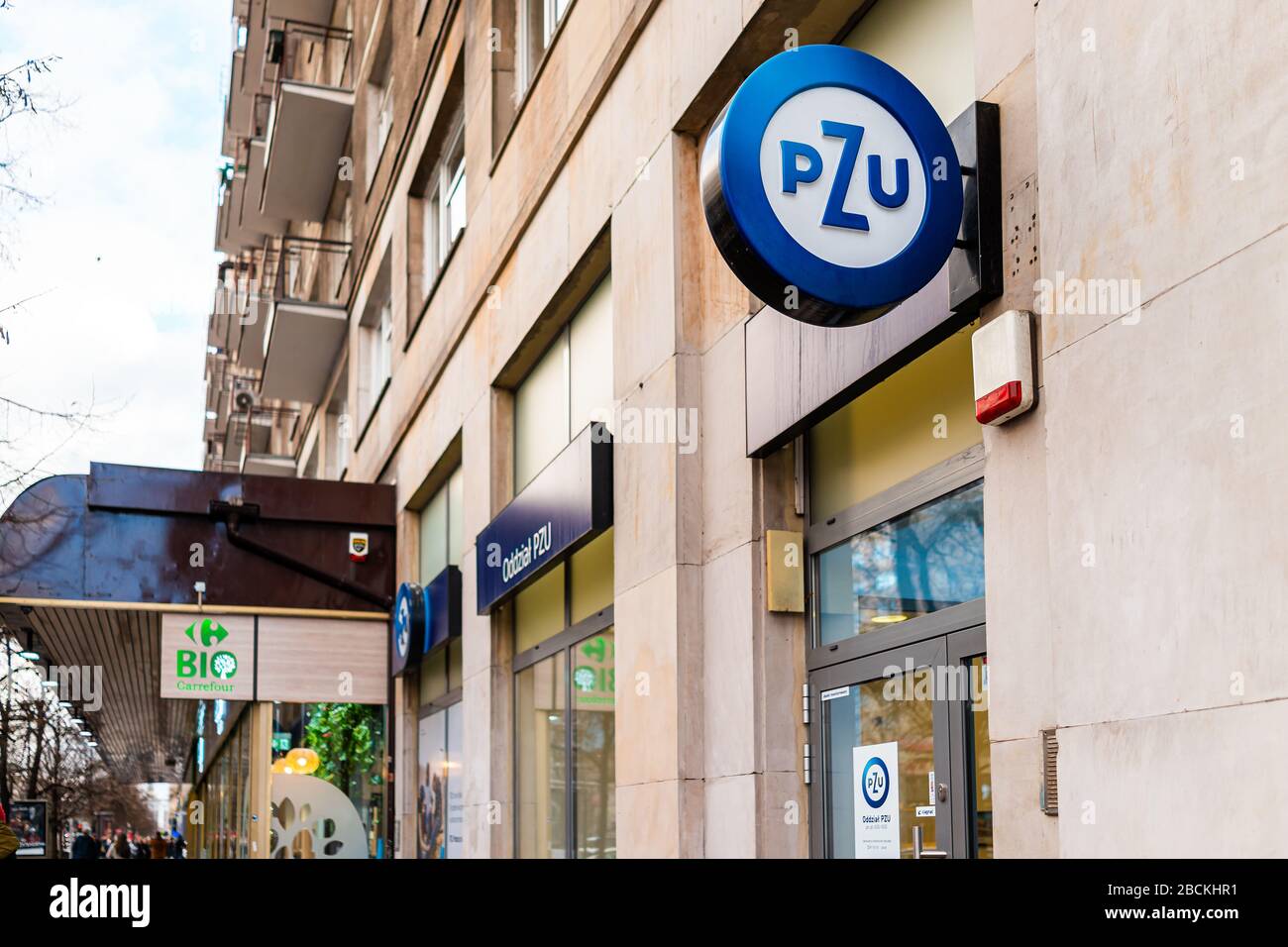 Varsovie, Pologne - 22 janvier 2019: Panneau pour la compagnie d'assurance PZU et Carrefour bio bio bio bio vert supermarché dans la rue dans le centre-ville Banque D'Images