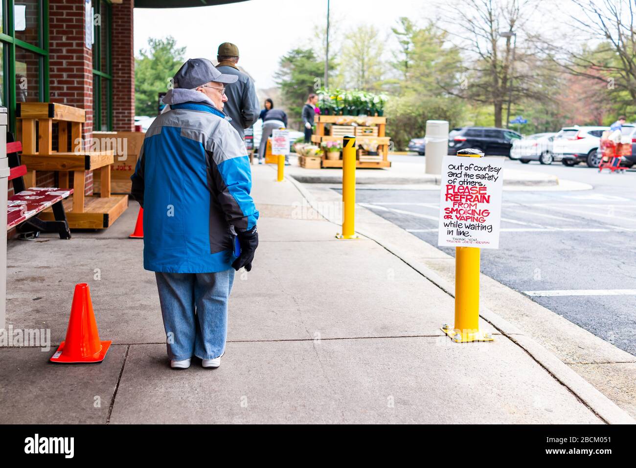 Reston, USA - 1 avril 2020: Le commerçant Joe's épicerie signe pour les clients de s'abstenir de fumer vaporing avec les gens, petite personne naine avec le standard Banque D'Images