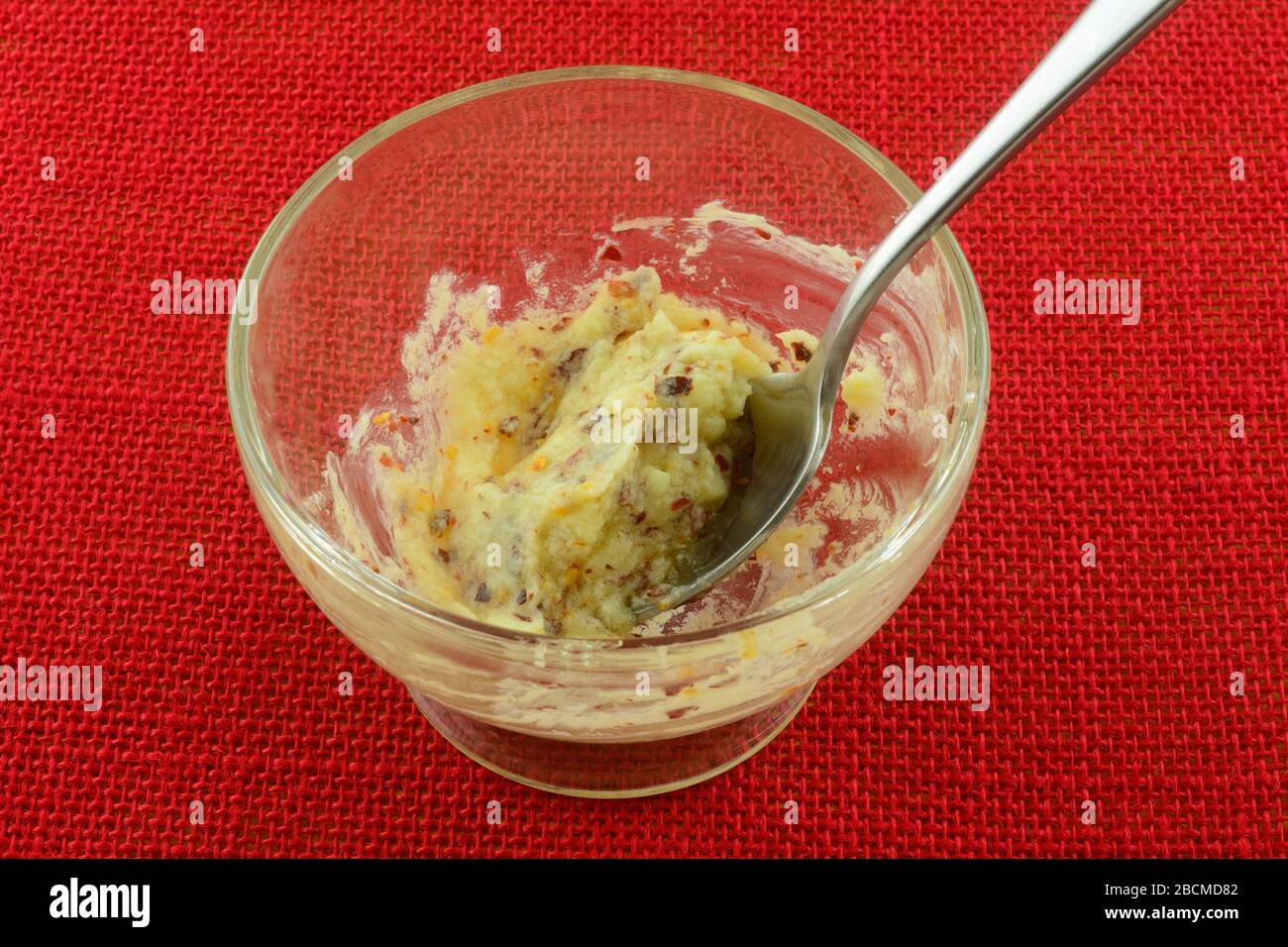 Sauce au beurre de miel au piment rouge épicé dans un bol en verre avec cuillère Banque D'Images