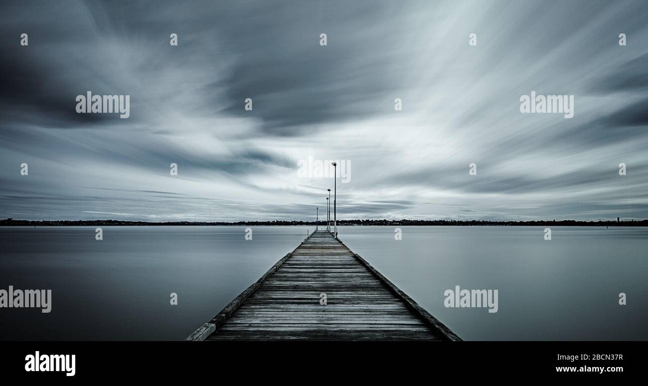 Jet de bois de Côme longue exposition avec nuages tourbillonnants et eau misteuse. Tons argent. Banque D'Images
