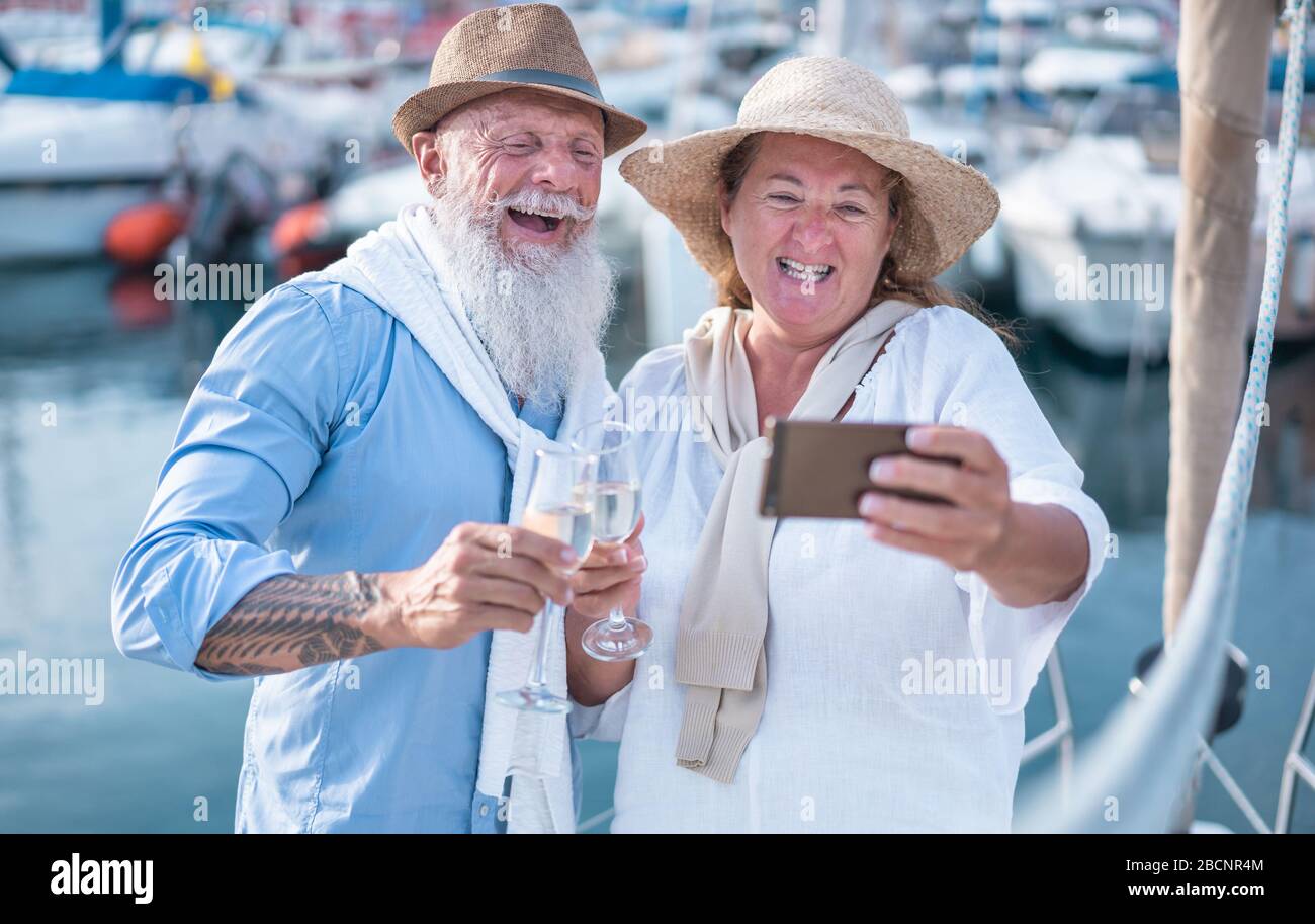 Heureux couple senior faisant selfie, applaudissent avec du champagne sur un voilier pendant les vacances d'anniversaire - Joyeux style de vie, l'amour, le voyage et les vacances Banque D'Images