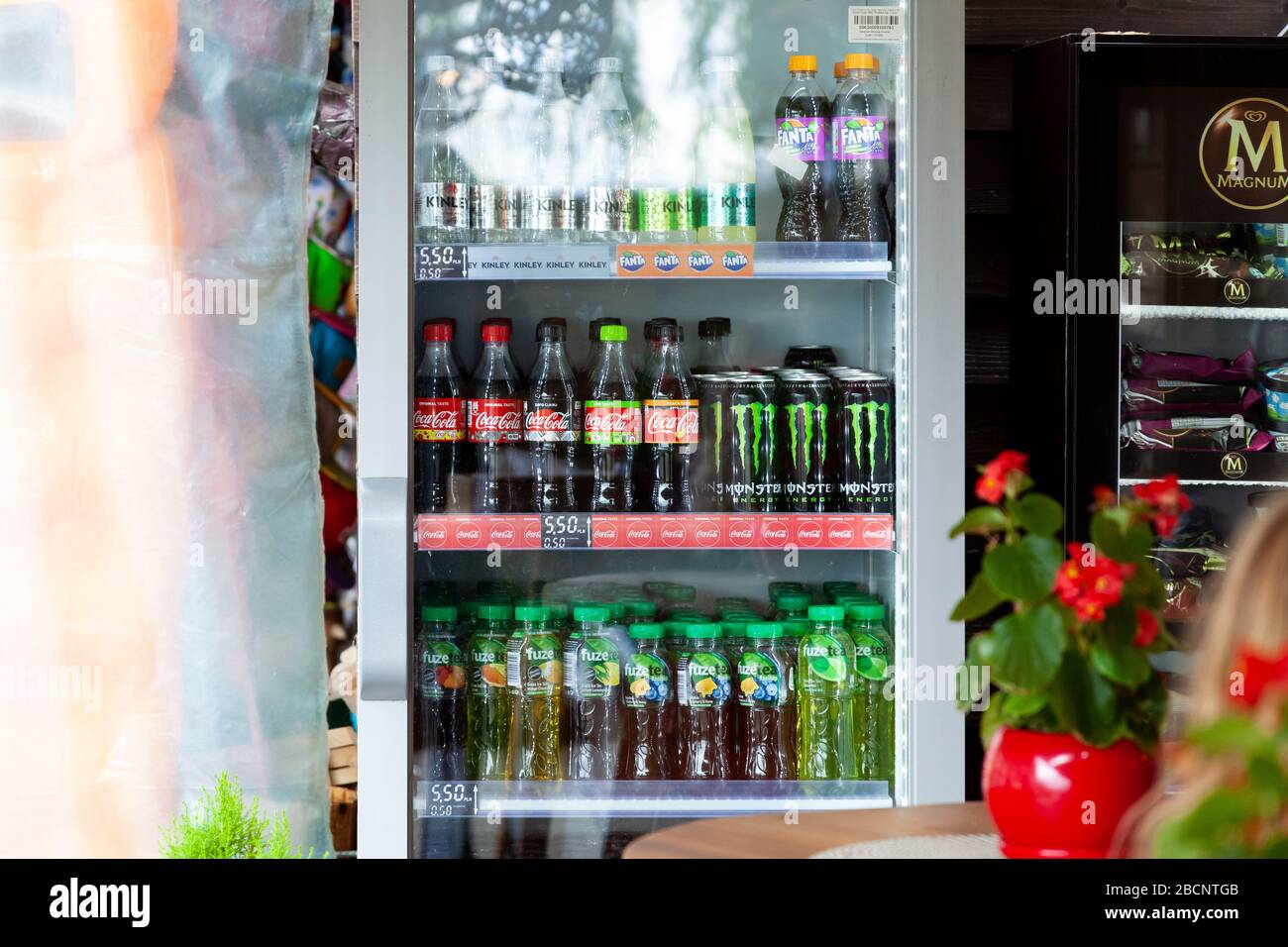 Diverses marques de boissons, des rangées de boissons froides dans un réfrigérateur vendus dans un petit magasin de proximité Coca-cola, Monster, Fuzetea, Fanta, Kinley Banque D'Images
