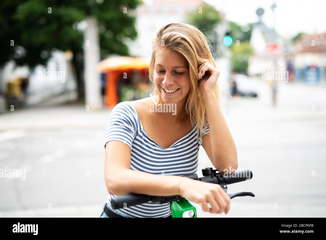 Une jolie jeune femme voyage en ville avec un scooter électrique Banque D'Images
