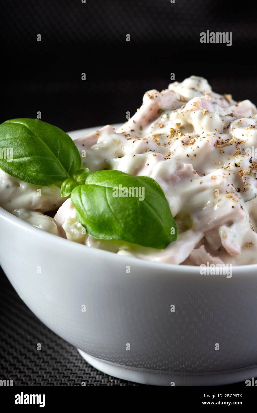 Salade de viande avec mayonnaise et herbes dans un bol blanc Banque D'Images
