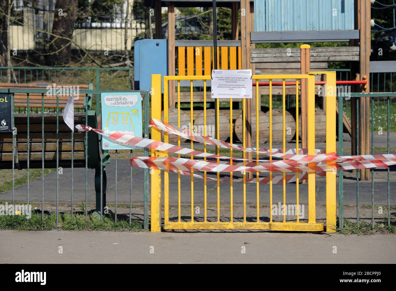 Swansea, Pays de Galles, Royaume-Uni - 5 avril 2020: Aire de jeux extérieure fermée. La zone de jeu pour enfants a verrouillé la porte avec du ruban rouge et blanc pour empêcher les gens de se rassembler. Coron Banque D'Images