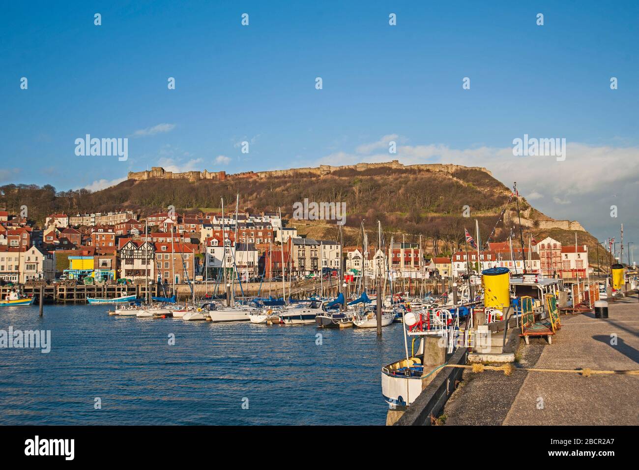 Communauté côtière en bord de mer avec port de plaisance et château sur la colline Banque D'Images