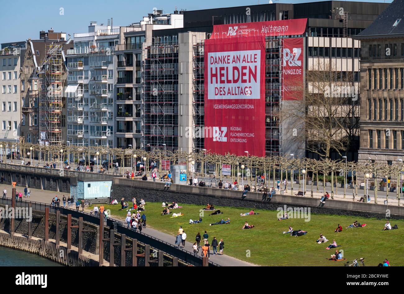 Une entreprise de construction a accroché une grande affiche sur la promenade du Rhin, grâce aux héros de la vie quotidienne, sur la façade d'une maison, DŸsseldor Banque D'Images