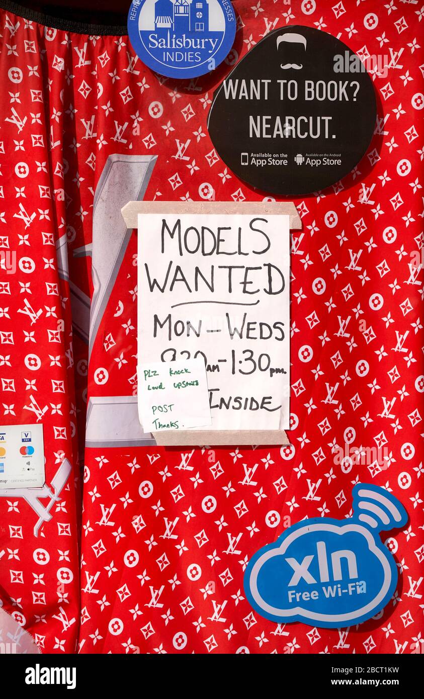 Affiche écrite à la main dans une fenêtre avec fond en tissu rouge et autocollants Banque D'Images