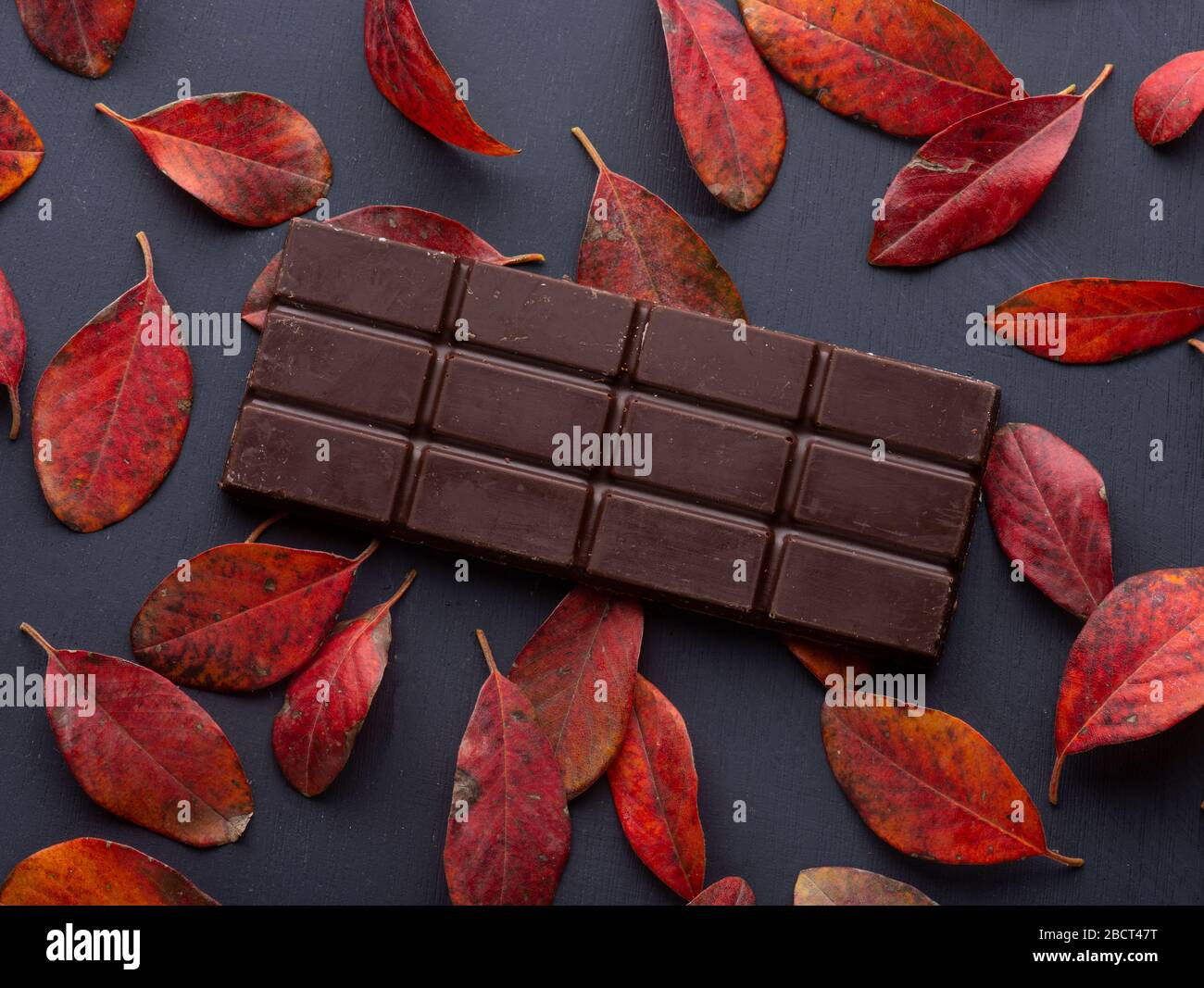 chocolat noir sur fond de feuilles rouges Banque D'Images