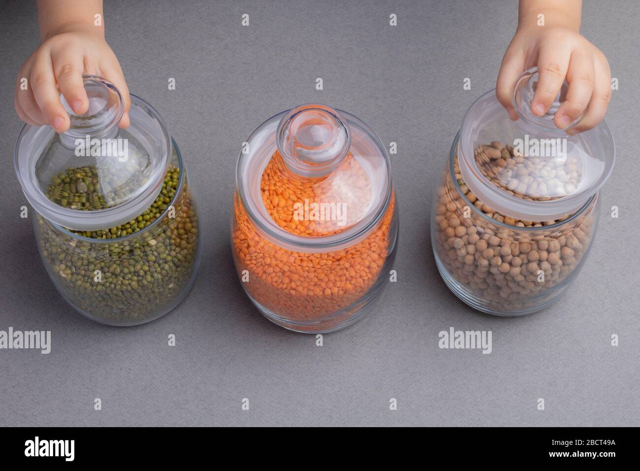 Différentes légumineuses dans des bocaux en verre pois chiches, pois verts, lentilles rouges Banque D'Images