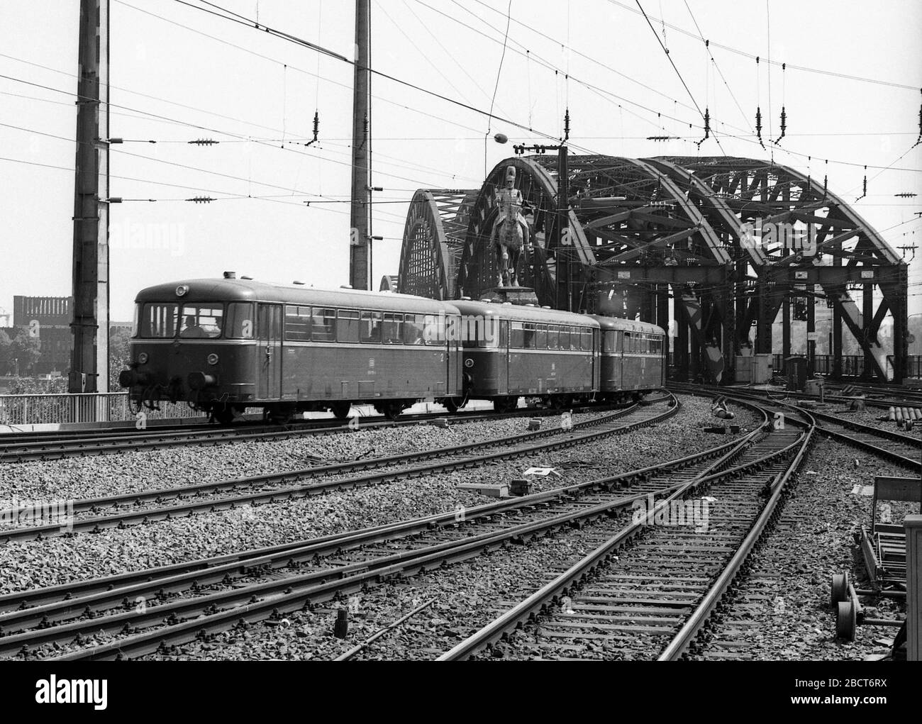 Train quittant la gare de Cologne en Allemagne 1975 avec des trains de locomotives électriques Banque D'Images