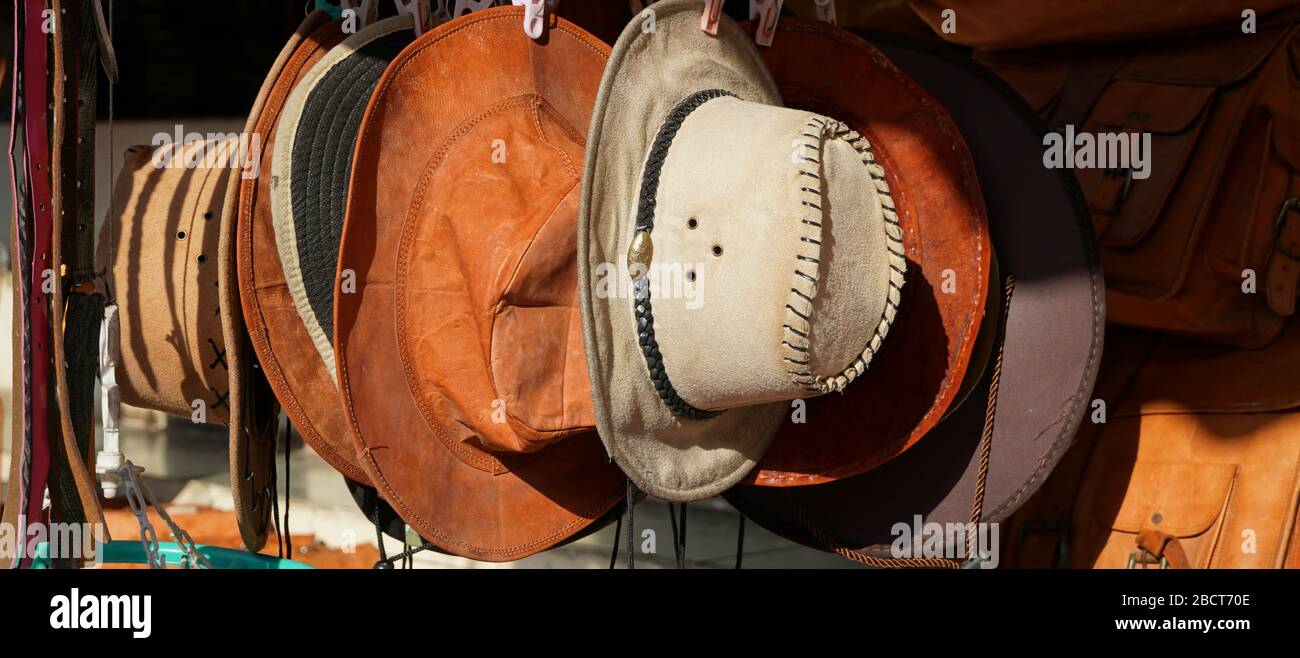Cowboy Noël. Chapeaux en cuir pur traditionnels de l'Ouest américain exposés à l'extérieur pour la vente au soleil. Ils pendent à côté l'un de l'autre. Banque D'Images