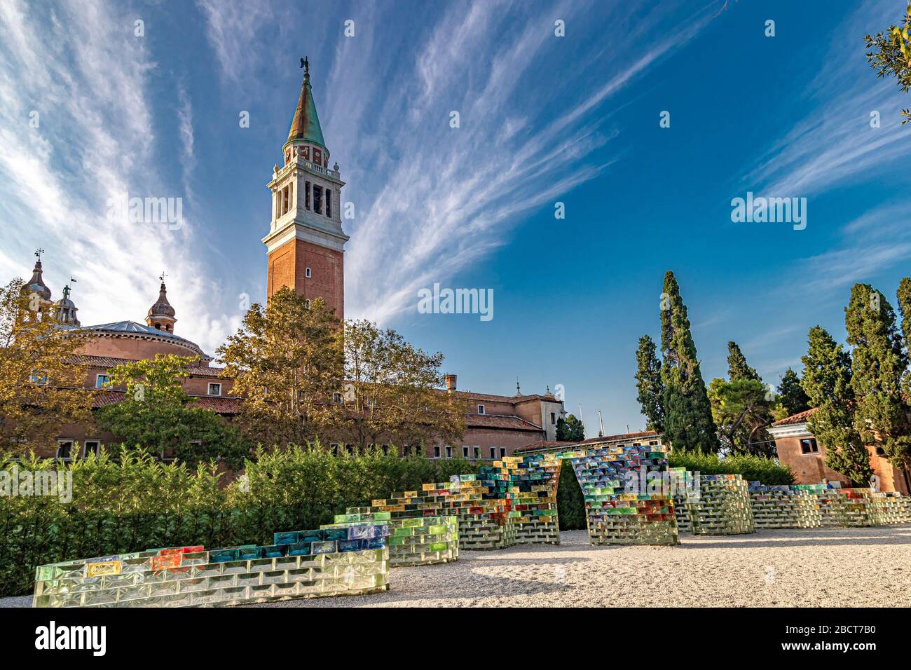 Un mur incurvé de blocs de verre de couleur créé par PAE White nommé Qwalala devant le clocher de San Giorgio Maggiore, Venise, Italie Banque D'Images