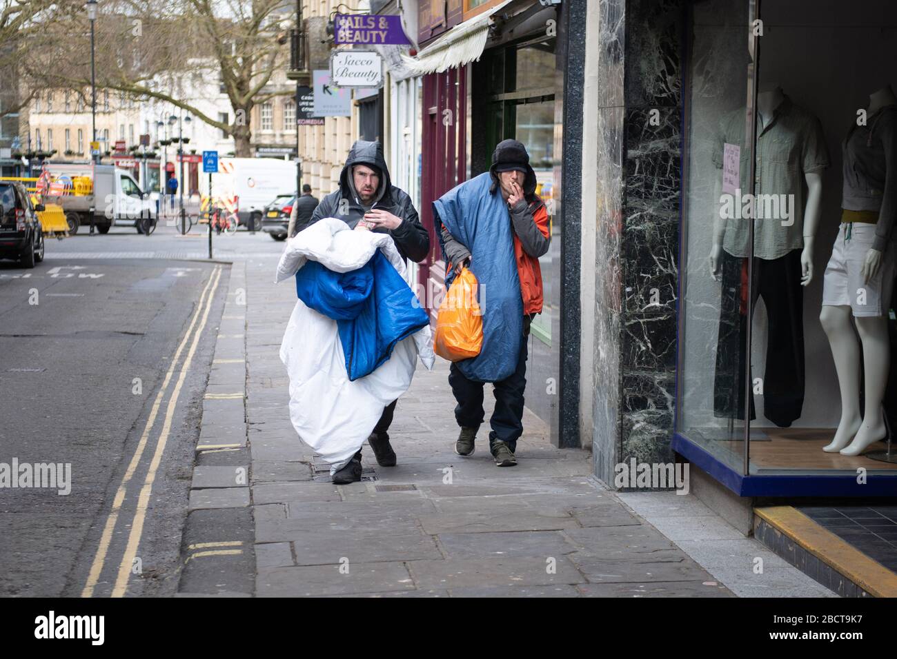 Bath, North Somerset, Royaume-Uni. 31 mars 2020. Deux sans-abri marchent dans les rues pendant le verrouillage dans le centre de Bath encombrant leur literie et les pers Banque D'Images