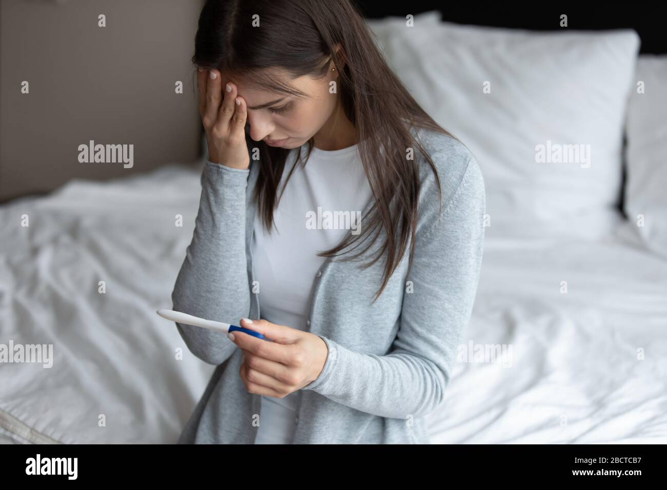 La jeune femme bouleversée se sent déçue du résultat du test d'ovulation Banque D'Images