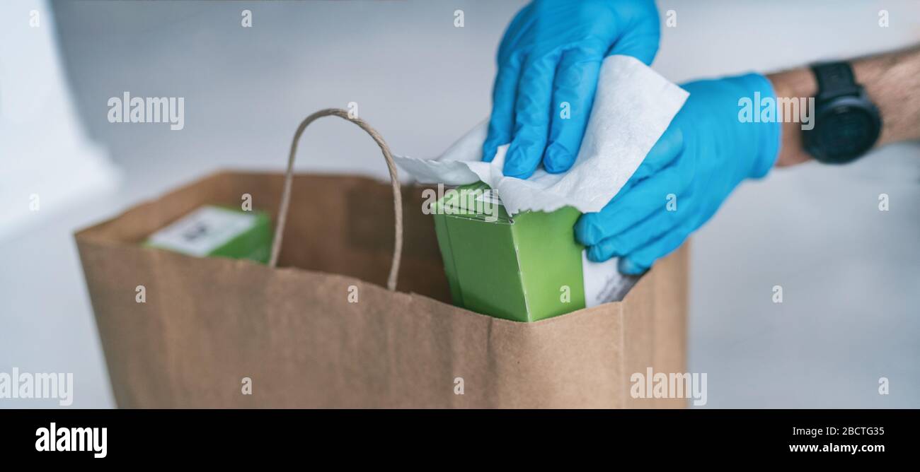 Coronavirus essuyant les emballages d'épicerie après avoir reçu la livraison à domicile porter des gants, en utilisant des lingettes désinfectantes désinfectantes pour essuyer les surfaces propres. Nettoyage du virus COVID-19. Banque D'Images