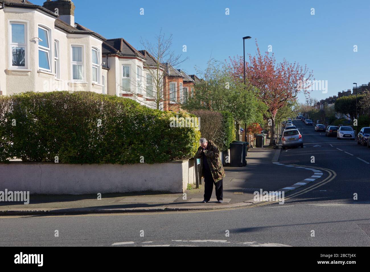 Londres, Royaume-Uni. Coronavirus. Un homme semble fumer ouvertement de crack cocaïne au coin des rues résidentielles, principalement désolées, pendant le covid- 19 Banque D'Images