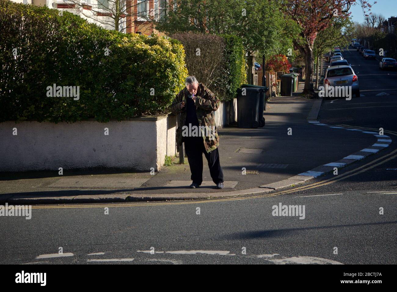Londres, Royaume-Uni. Coronavirus. Un homme semble fumer ouvertement de crack cocaïne au coin des rues résidentielles, principalement désolées, pendant le covid- 19 Banque D'Images