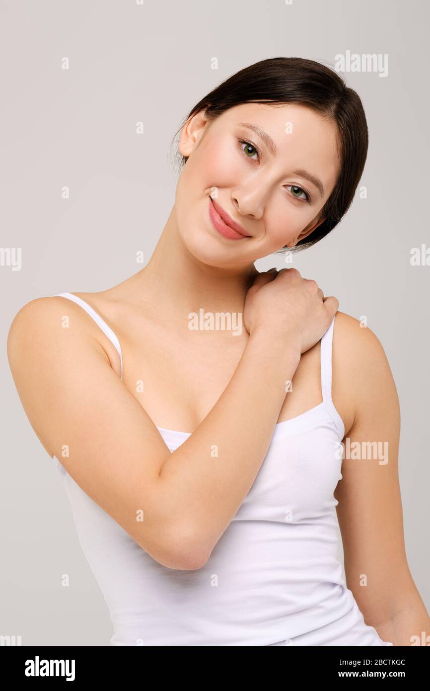 Portrait de la belle fille asiatique heureuse dans le t-shirt blanc et le maquillage naturel Banque D'Images