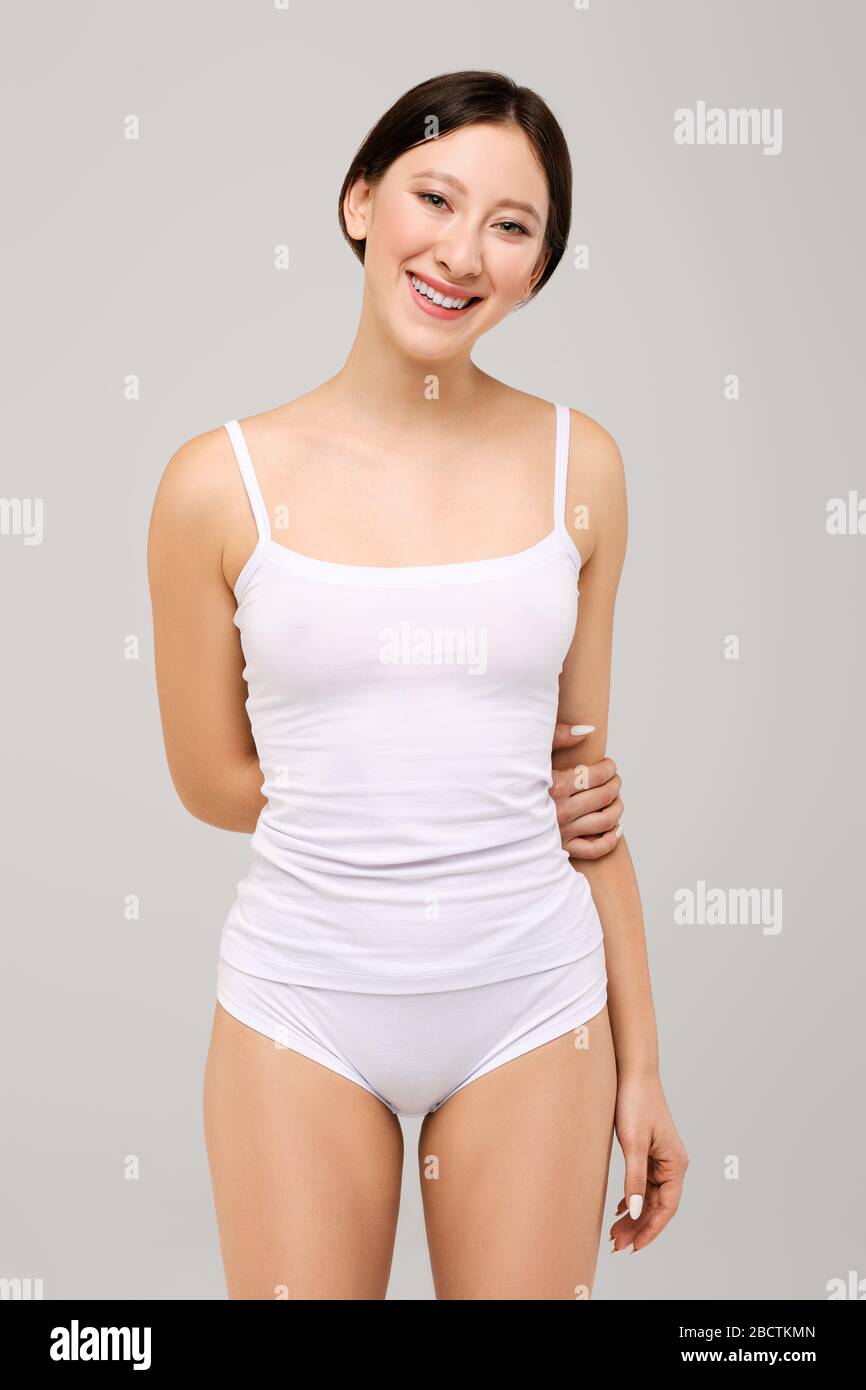 Jolie et heureuse fille asiatique dans un t-shirt blanc et maquillage naturel Banque D'Images