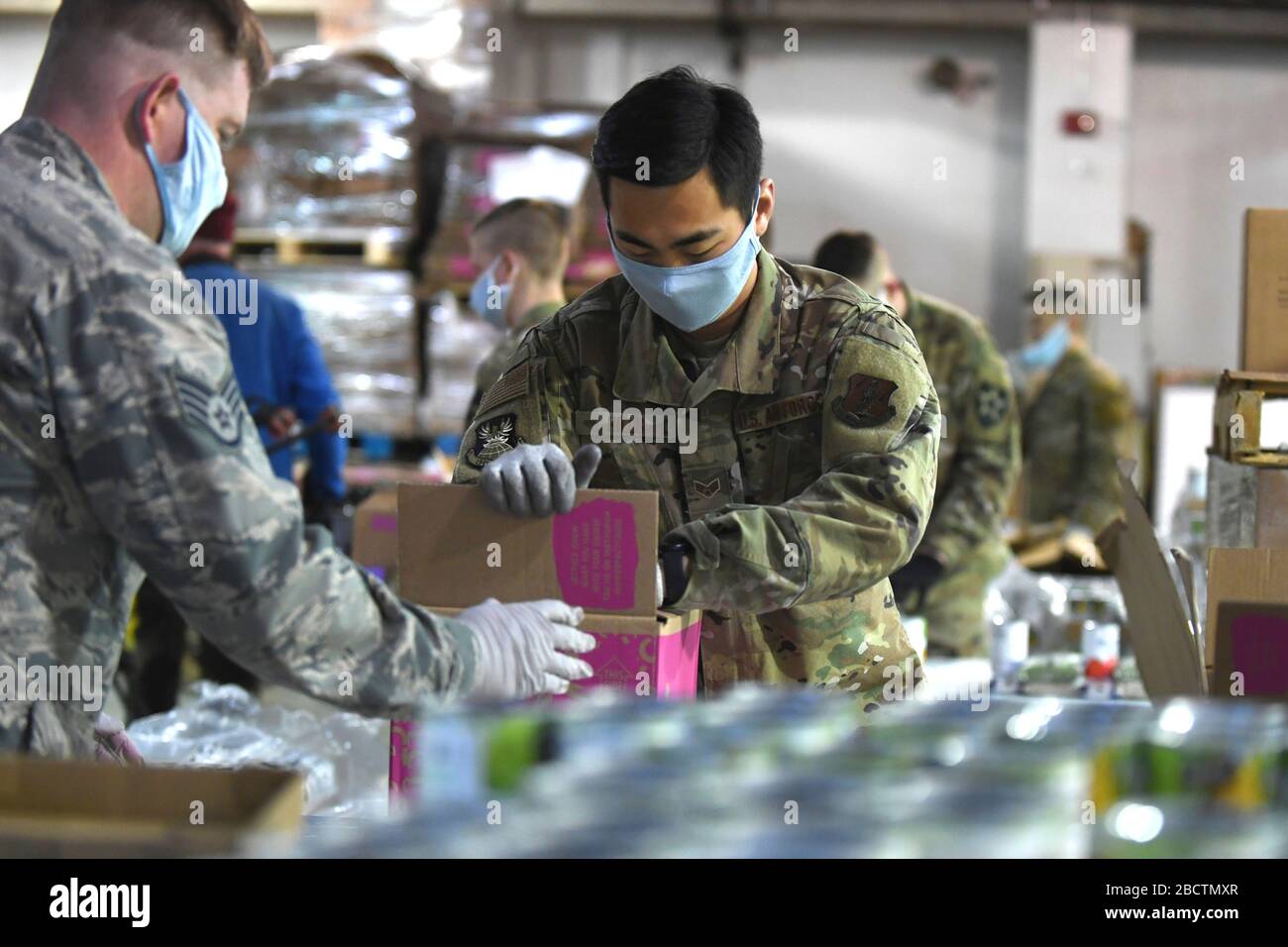 U.S. Air Force Senior Airman Young Hills, emballe une boîte avec de la nourriture en conserve à la Food Bank pour aider avec COVID-19, soulagement du coronavirus 3 avril 2020 à Lakewood, Washington. Banque D'Images