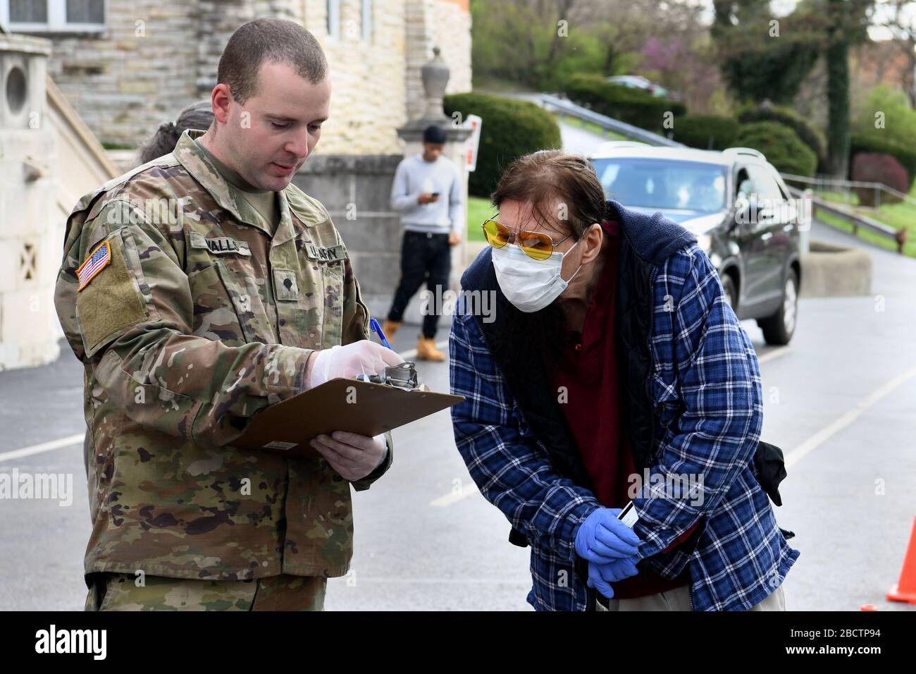 CPS de l'armée américaine. Darrell Walls passe en revue une liste d'achats avec Dann Smith, un résident local, tout en soutenant la mission de secours humanitaire de l'opération Steady Resolve avec le marché mobile des récoltes saines de la FreeStore Food Bank à Cincinnati, Ohio le 2 avril 2020. Plus de 400 membres de la Garde nationale de l'Ohio ont été appelés à appuyer les efforts de distribution alimentaire dans 12 endroits de l'Ohio, desservant plus de 11 millions d'Ohioans dans les 88 comtés. (ÉTATS-UNIS Photo de la Garde nationale aérienne par Tech. Sgt. Shane Hughes) Banque D'Images