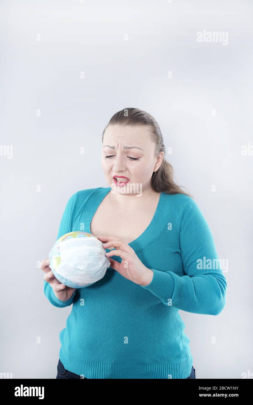 Concept de pandémie de grippe mondiale. Femme du monde entier avec masque médical sur fond de studio blanc. Problème mondial covid. Banque D'Images