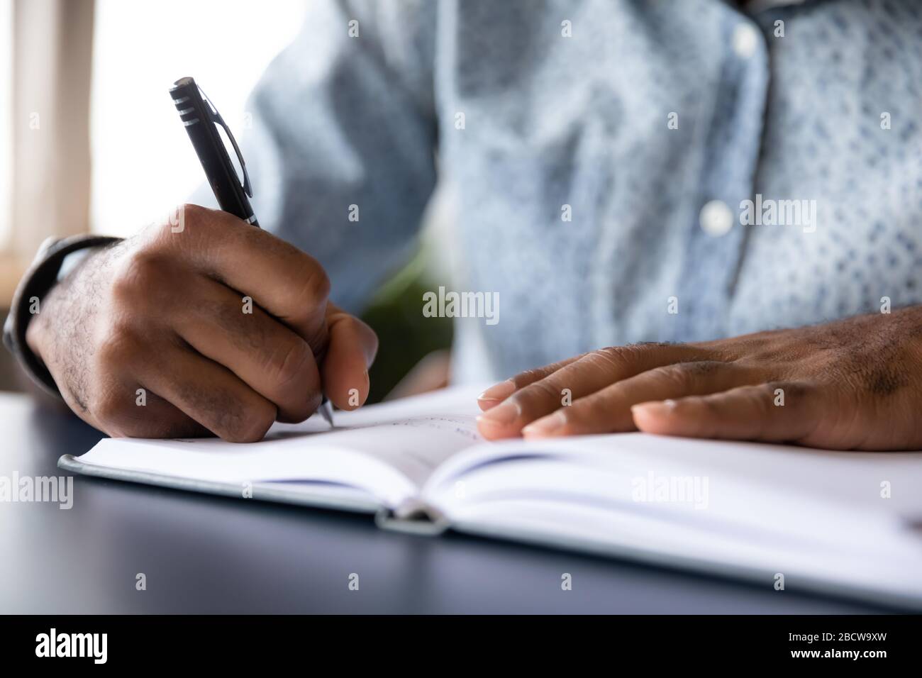 Gros plan sur l'écriture de l'homme biracial dans l'ordinateur portable Banque D'Images