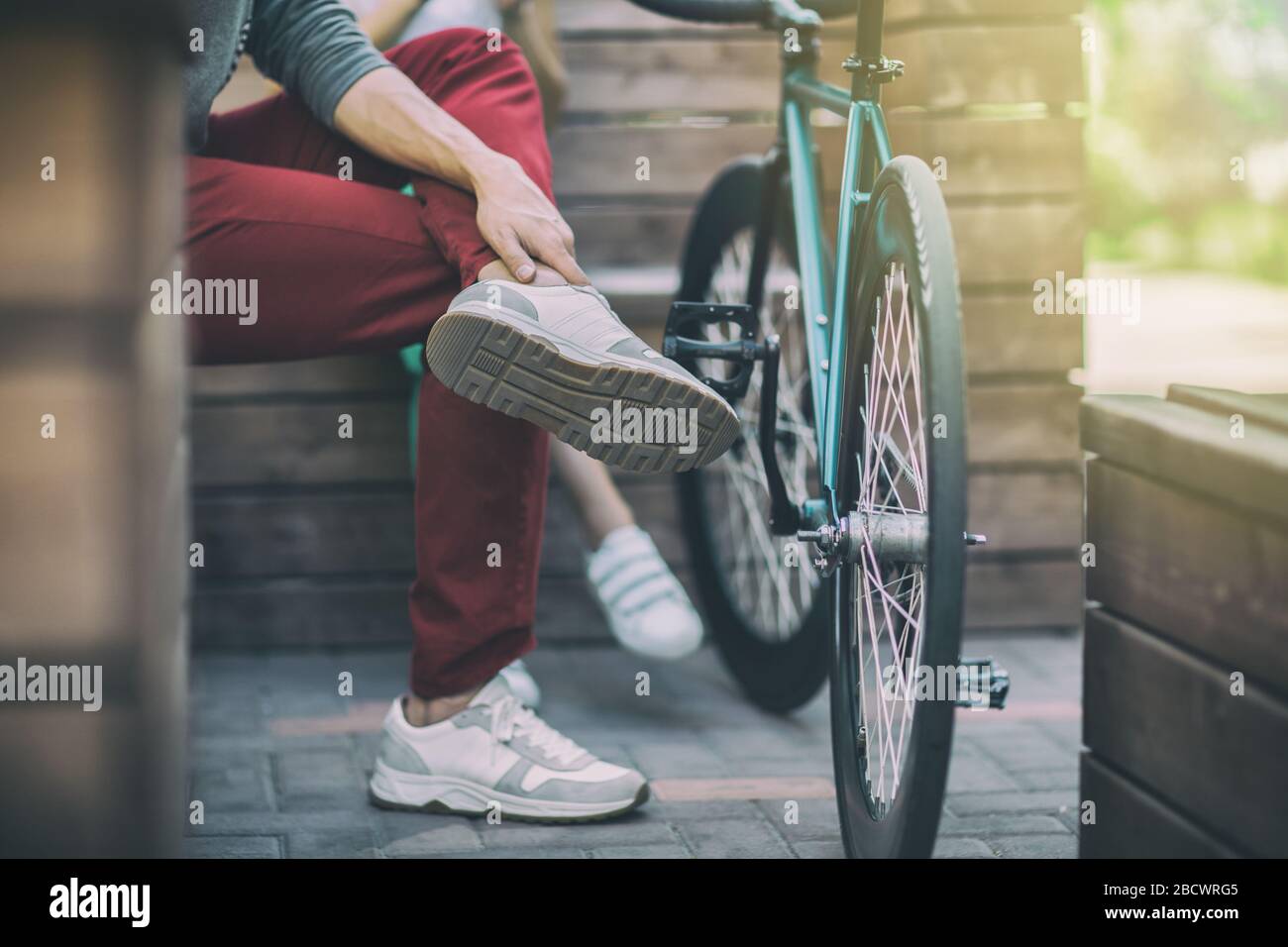 Jeune homme en pantalon rouge à côté de la piste cyclable Banque D'Images