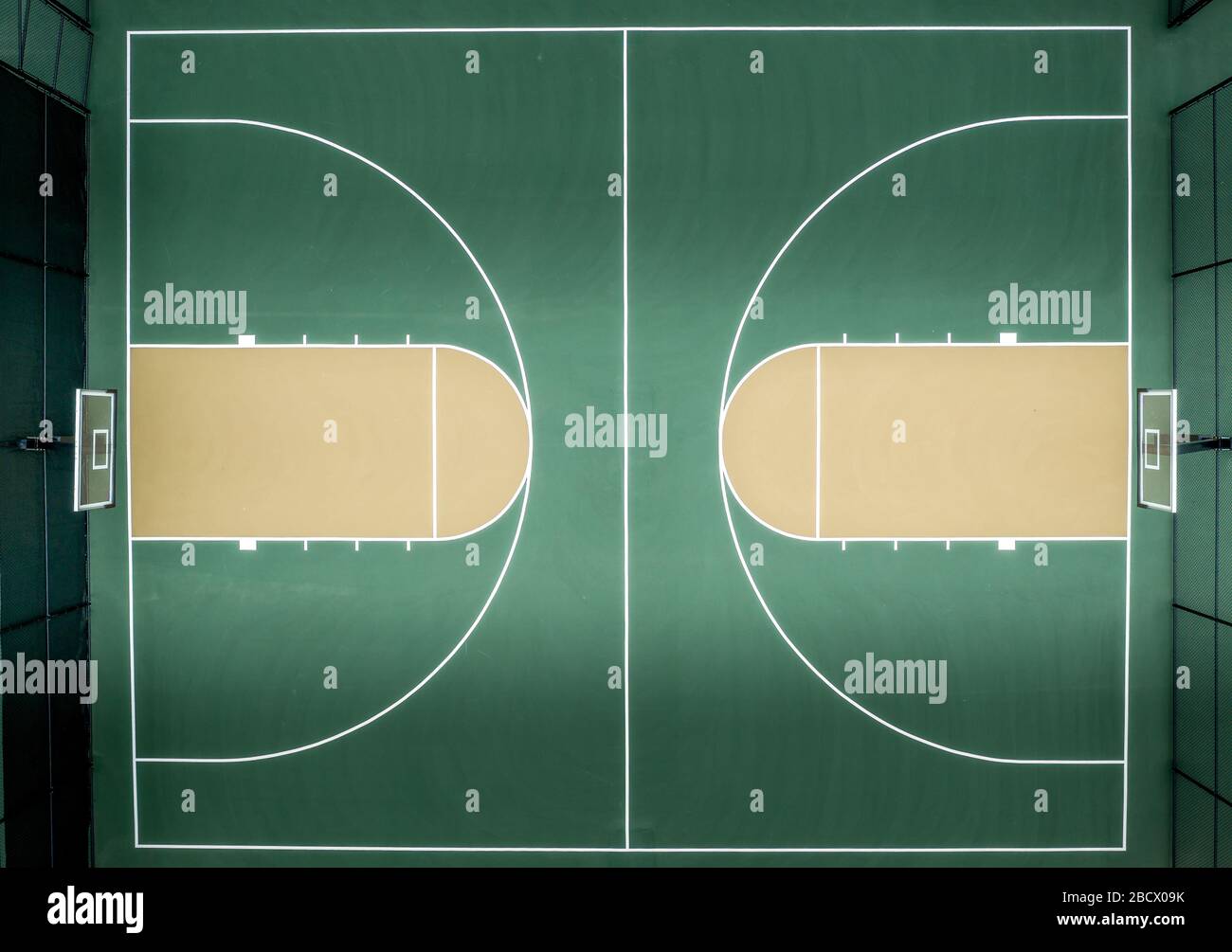 Vue aérienne du haut vers le bas du terrain de basket-ball multisports du quartier avec pavé vert Banque D'Images
