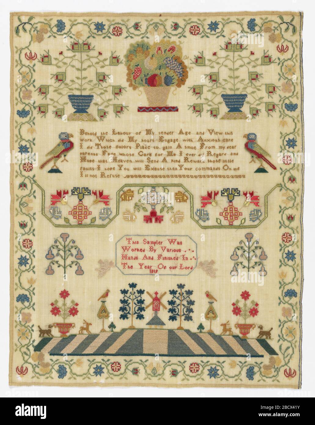 Echantillonneur. Recherche sur l'échantillonneur Progressa de motifs et de textes isolés à l'intérieur d'une bordure fleurie courbe. La toile de fondation en laine est très fine, et la broderie de mot à mot montre à travers de l'autre côté. Echantillonneur Banque D'Images