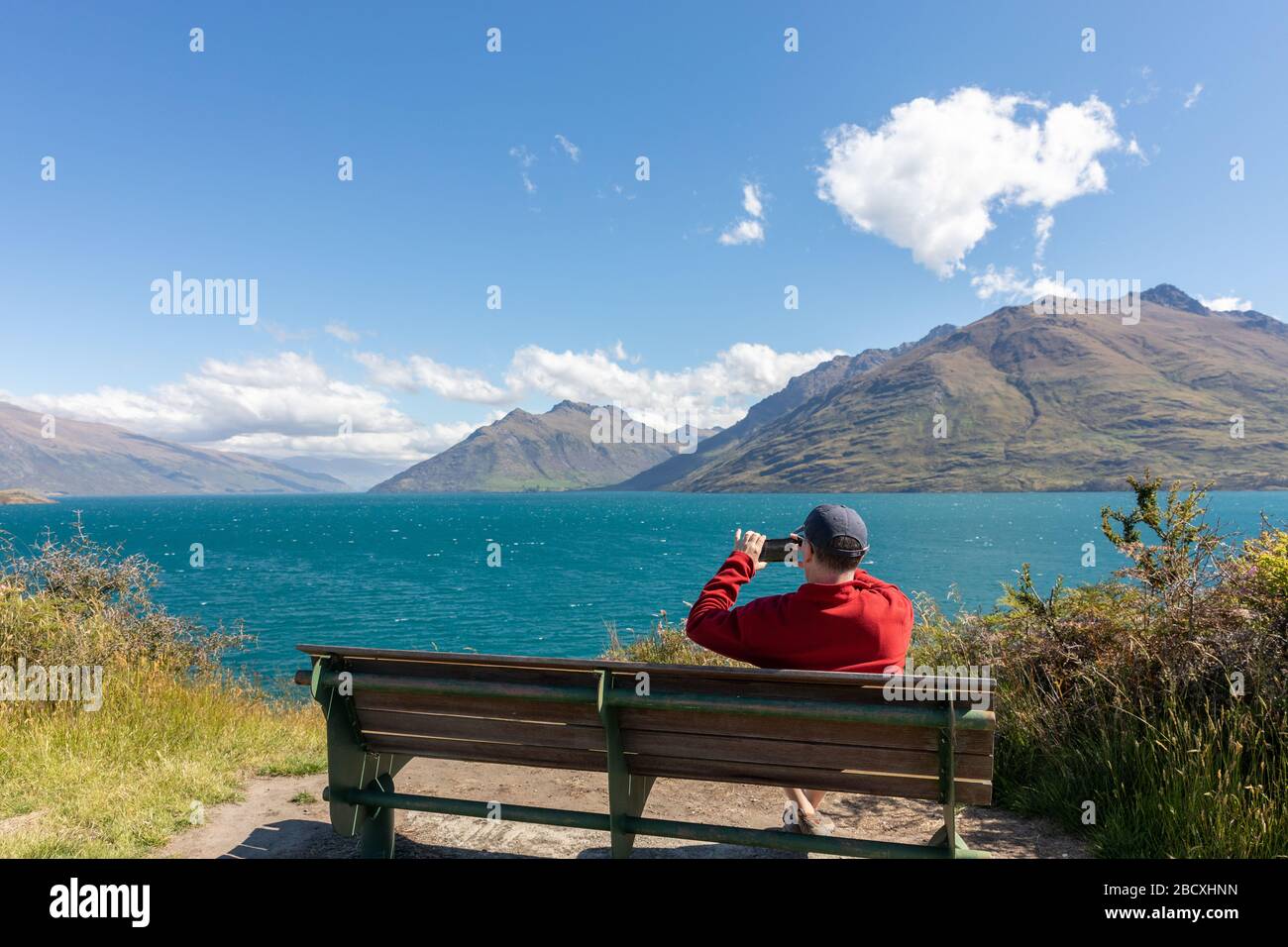 Un homme prenant une photo du lac Wakatipu de la piste Kelvin Banque D'Images