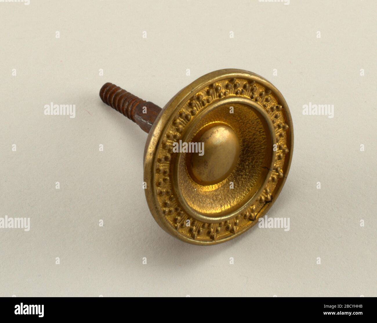 Bouton. Recherche dans ProgressRepousee tête avec bossage entouré de moulage de feuilles. Vis filetée à l'arrière. Bouton Banque D'Images