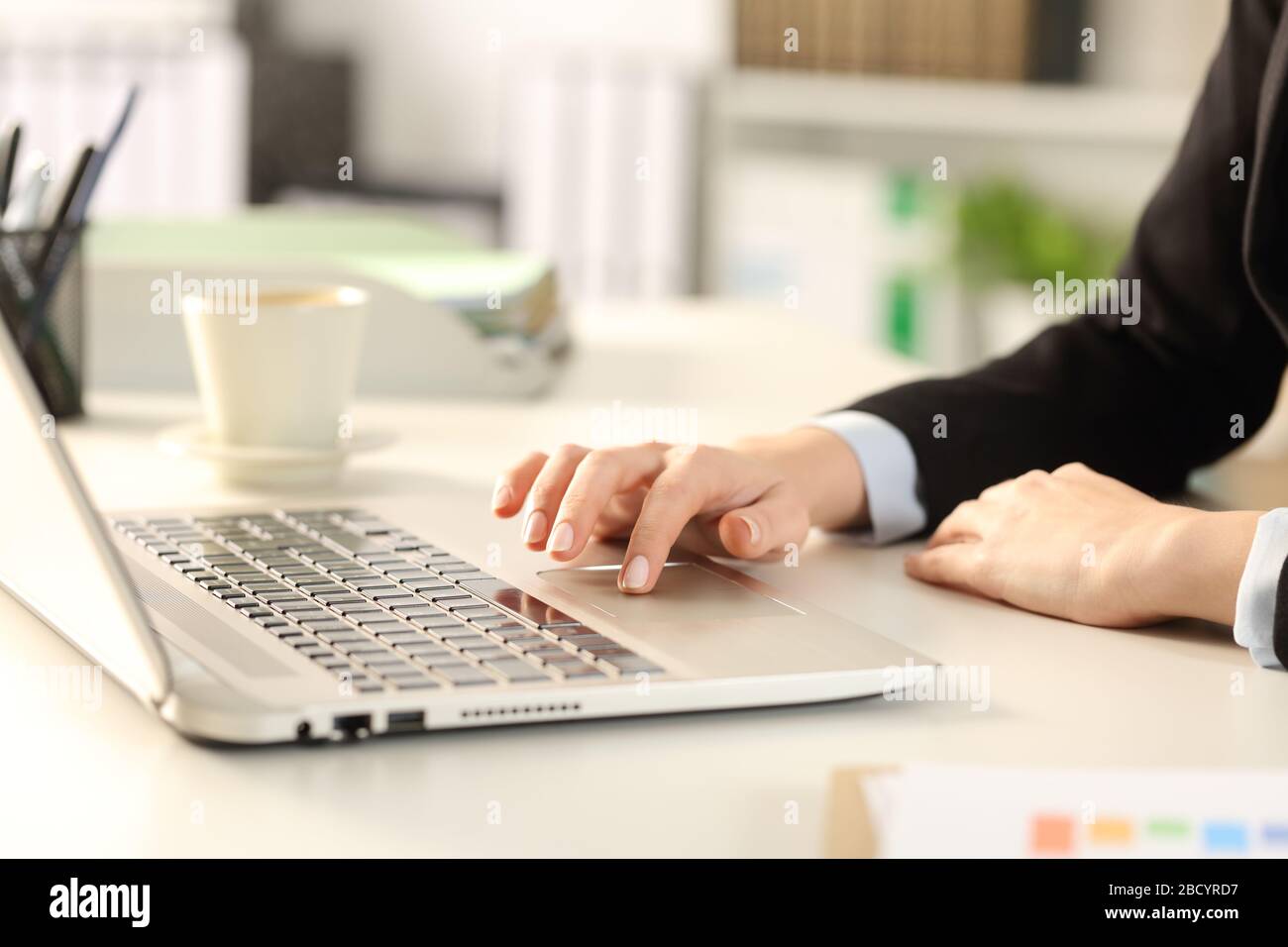 Gros plan sur la main d'une femme de direction à l'aide d'un pavé tactile pour ordinateur portable assis sur un bureau Banque D'Images