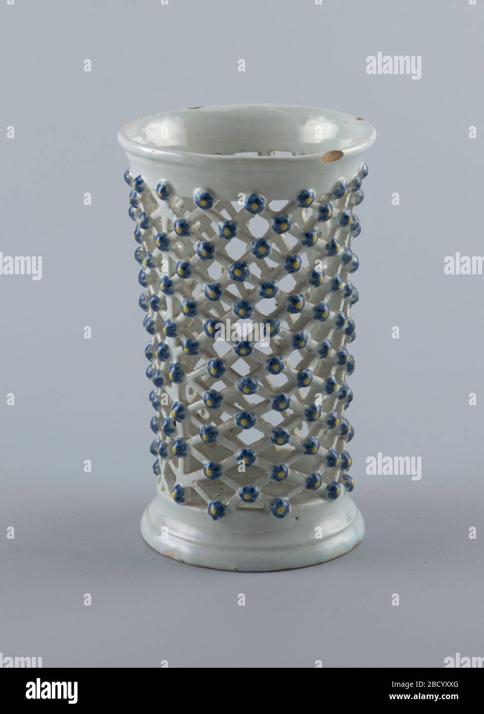 Vase. Recherche dans le vase ProgressHigh percé sous forme d'une bouteille de réseau avec des fleurs aux croisements. Vase Banque D'Images