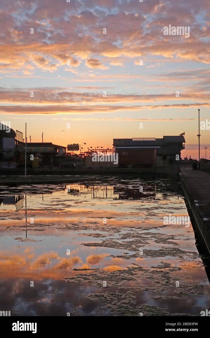 Hastings, East Sussex, 6 avril 2020. Lever du soleil derrière le Life Boat House de l'autre côté du lac déserté. Très peu de gens ce matin. Doux avec ciel clair qui se trouble et avec des prévisions de pluie légère pour plus tard. Carolyn Clarke/Alay Live News Banque D'Images
