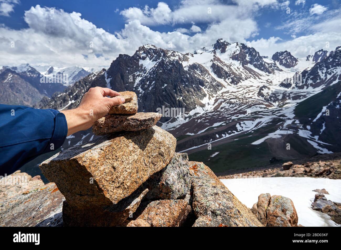 Traveler mise sur la pyramide en pierre dans les montagnes enneigées Banque D'Images