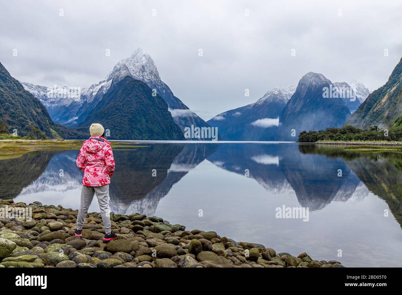 Jeune fille de voyage asiatique de l'arrière se tenant à Milford Sound; Fiordland National Park, South Island, Nouvelle-Zélande Banque D'Images
