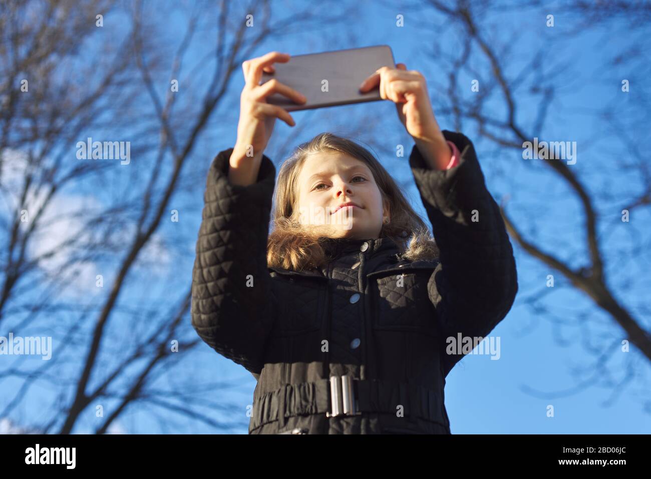 Portrait extérieur fille enfant de 8, 9 ans avec smartphone Banque D'Images