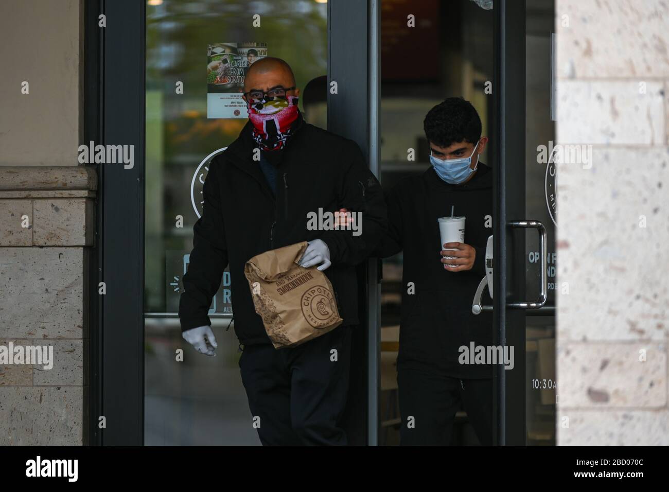 Un homme quitte un restaurant Chipotle tout en portant un masque et des gants près du centre commercial Ontario Mills, le samedi 4 avril 2020, en Ontario, en Californie, aux États-Unis. (Photo par IOS/Espa-Images) Banque D'Images