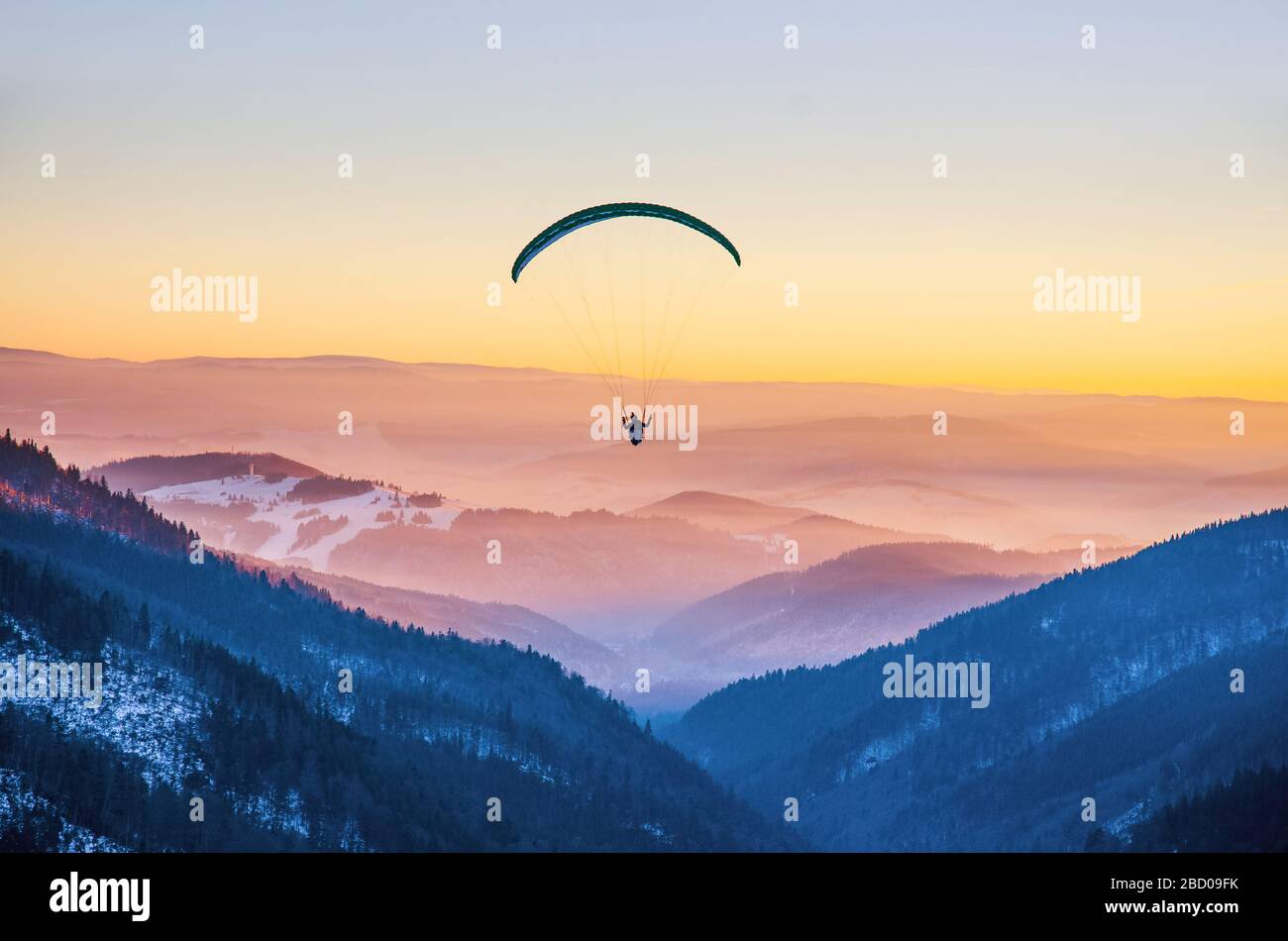 Silhouette de parapente survolant la vallée de la montagne malteuse dans de belles couleurs chaudes au coucher du soleil - sport, fonds d'écran actifs pleine de liberté. Modification de l'arrière-plan sp Banque D'Images