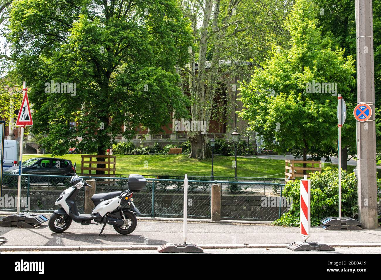 Scooter séjour dans la rue de la ville près d'un parc en été journée ensoleillée à Baden-Baden. Allemagne. Contexte du bâtiment. Banque D'Images