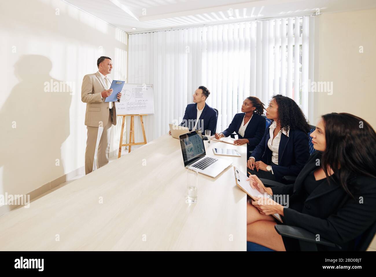 Les chefs de département participant à une réunion avec le PDG de l'entreprise et à l'écoute de la nouvelle stratégie dont il parle Banque D'Images