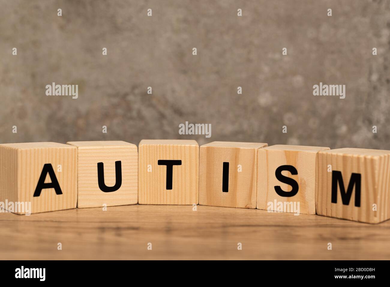 Cubes autistes sur table en bois sur fond gris Banque D'Images