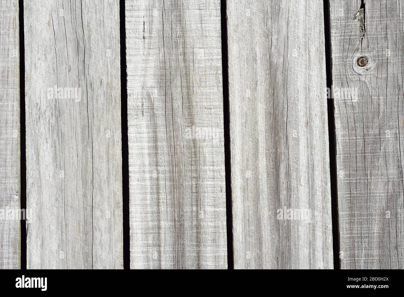 Détail de clôture en bois blanchie au soleil avec lamelles verticales. Banque D'Images